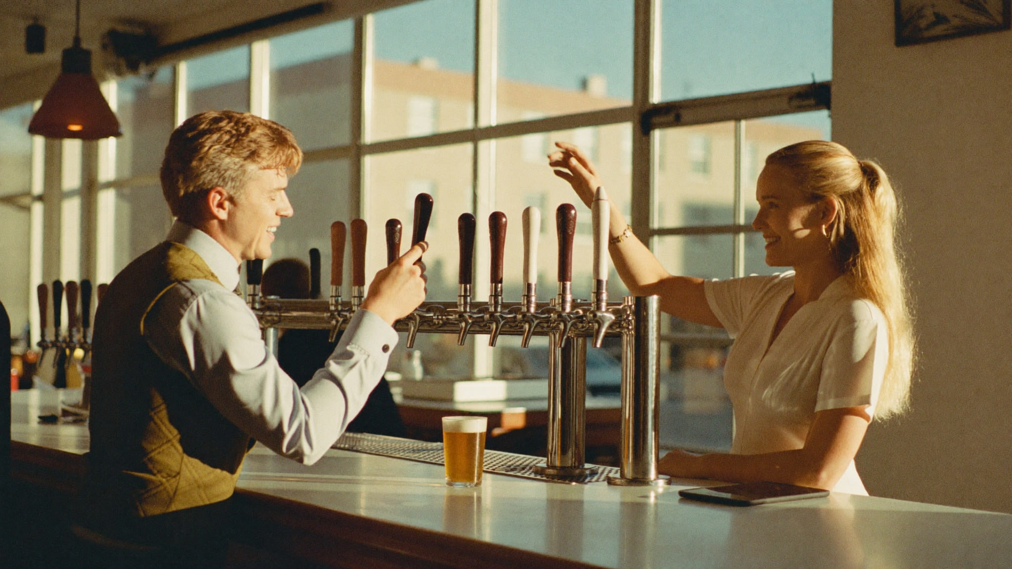 A sales representative talking with a bar owner at the counter of a neighborhood bar near the draft taps